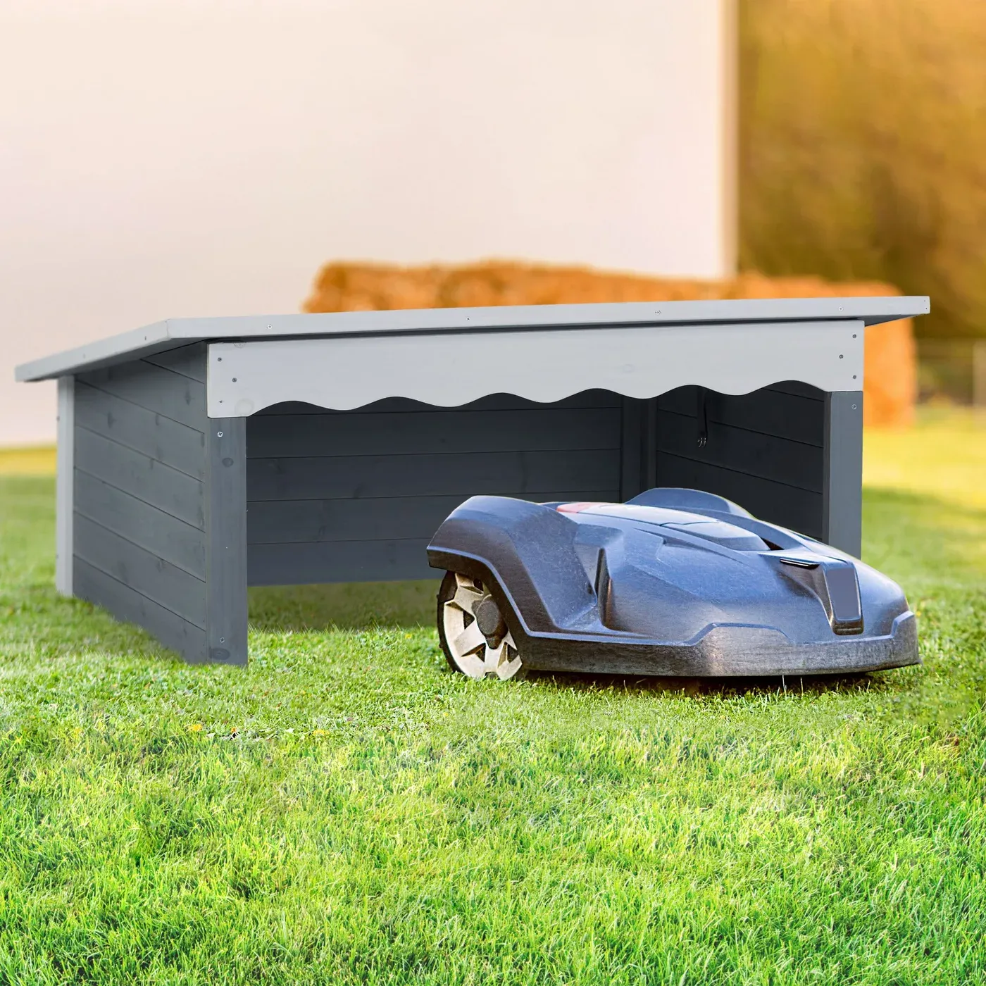 Le garage Relaxdays sur une pelouse, un robot tondeuse gris sortant par sa façade ouverte